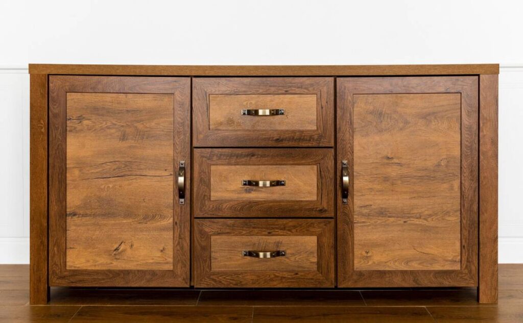 Wooden sideboard cabinet with two doors and three drawers, featuring metal handles, against a white wall.