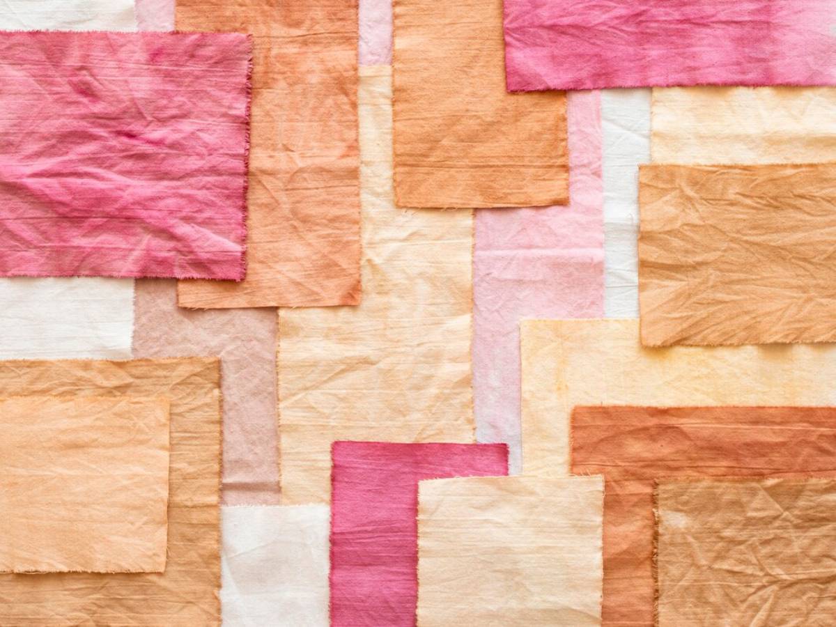 Abstract collage of variously sized, pastel-coloured tissue papers overlapped on a flat surface. 