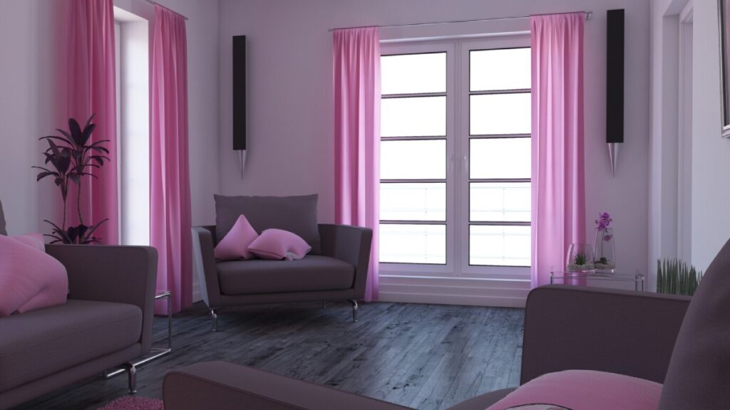 Modern living room with pink curtains, grey furniture, and indoor plants. Bright daylight from large windows.