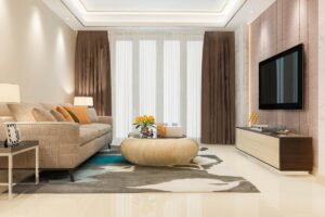 Modern living room with a beige sofa, patterned rug, and wall-mounted TV. Neutral tones and contemporary decor.