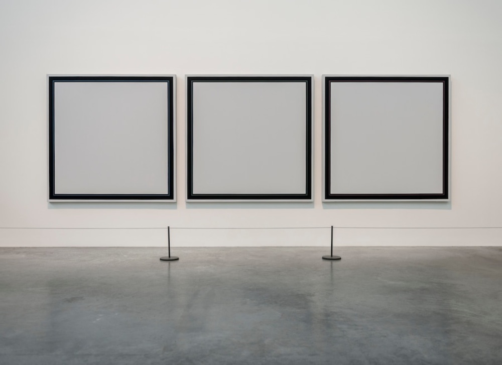  Three large, framed, monochrome paintings template displayed side by side on a gallery wall.