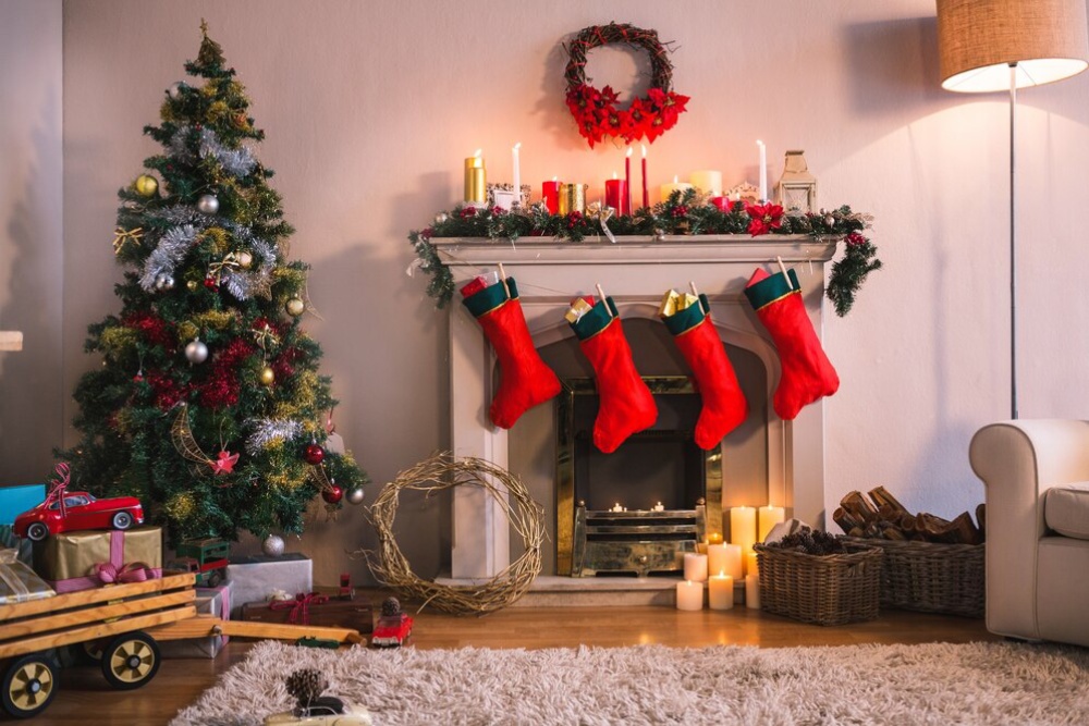 Cosy living room decorated with Christmas tree, stockings on fireplace, and festive ornaments. 