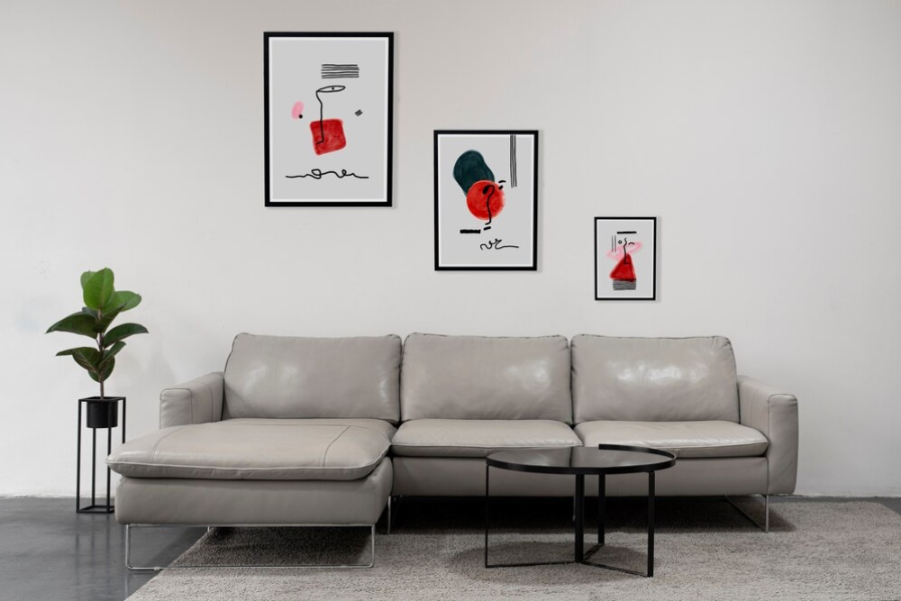  Modern living room with grey sofa set, black coffee table, and abstract art on white walls. 
