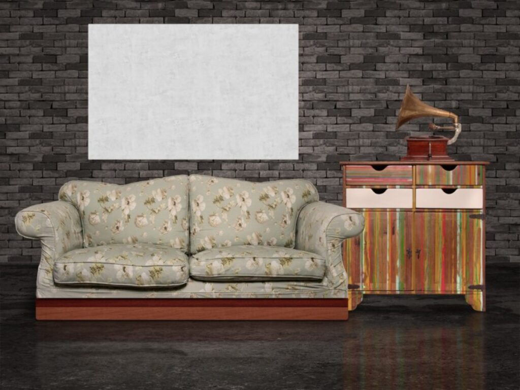 Floral-patterned sofa and colourful striped cabinet with a vintage phonograph against a dark brick wall, empty canvas overhead.