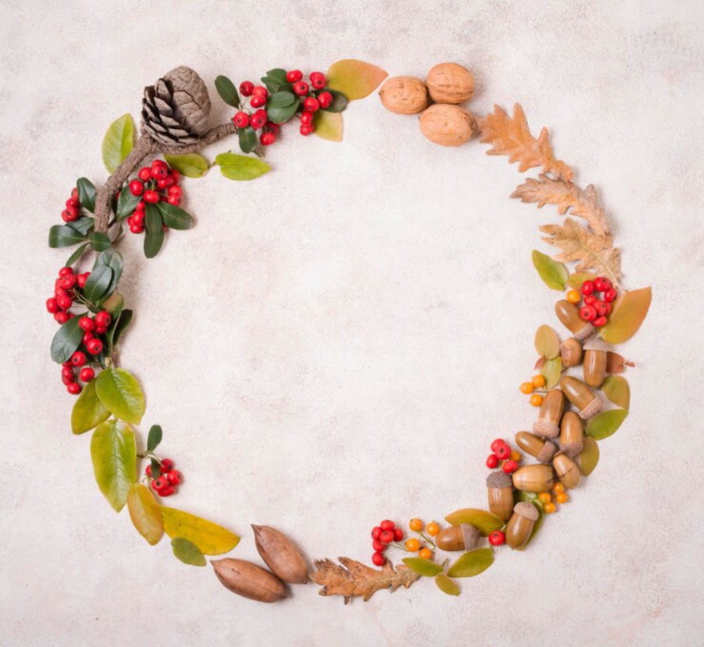 Circular autumn wreath made of leaves, nuts, berries, and pine cones on a textured background.