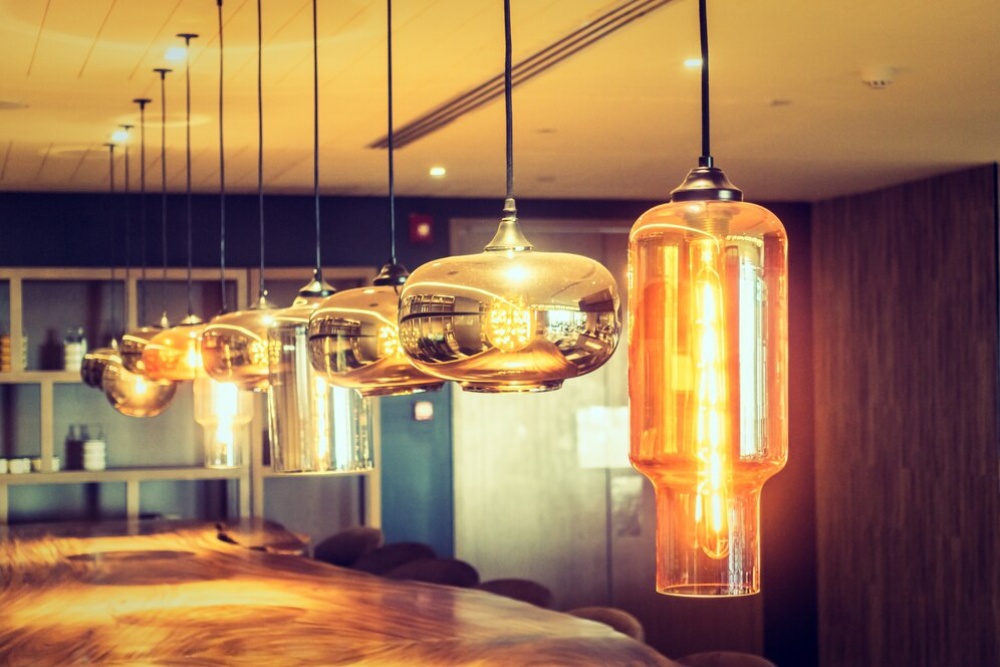  Modern hanging lights with warm glow illuminate a stylish interior bar area.