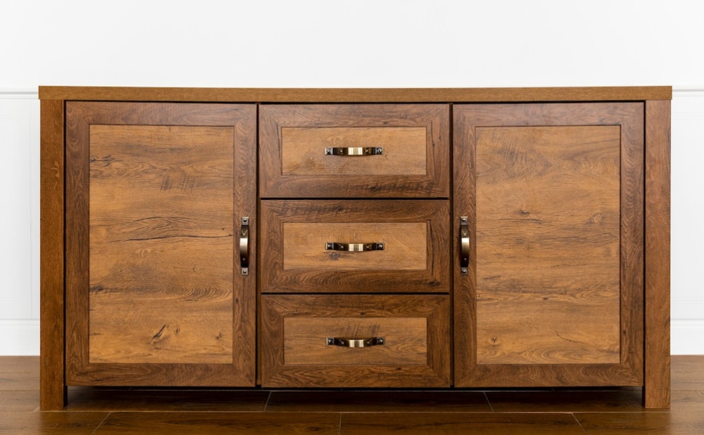  A large wooden cabinet with two cupboards and three drawers, featuring silver handles, against a white wall background. 