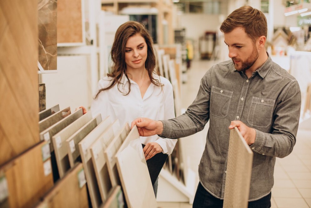  A man and woman examining tile samples in a store.